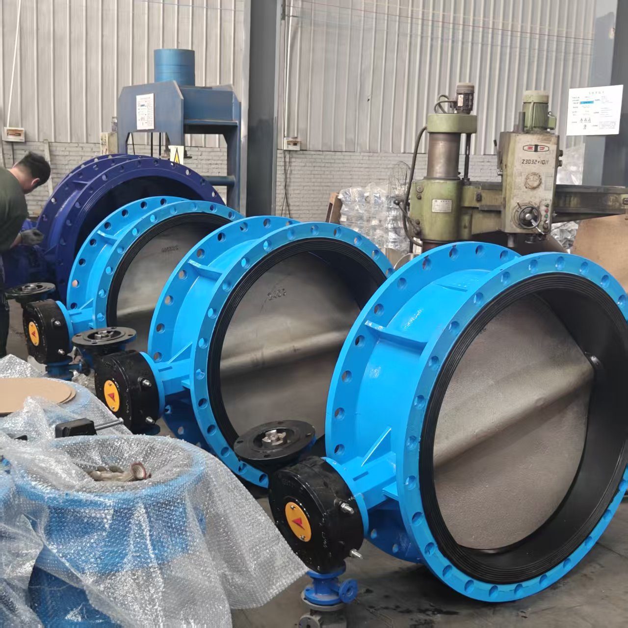 Multiple large-diameter flanged butterfly valves lined up in factory